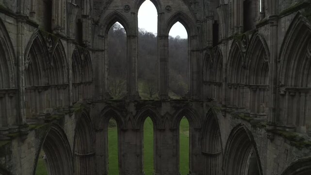 Aerial shot of the historic Rievaulx Abbey ruins surrounded by lush greenery in North Yorkshire, UK