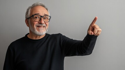 Naklejka premium Middle-aged man with a calm expression, pointing towards the side as if making a suggestion, against a neutral background