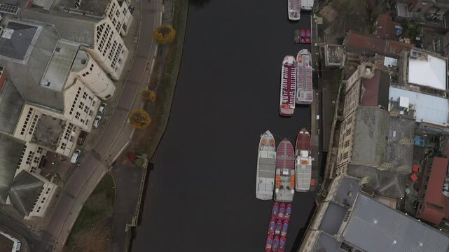 A drone shot of the River Ouse with moored boats and surrounding architecture in York, UK