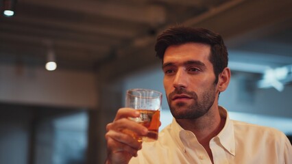 Profile closeup of smiling smart man in white shirt drinking cocktail in Old fashioned of special party beverage vibrant at nightclub on Friday meeting night time at luxurious counter bar. Vinosity.