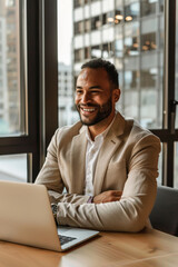 Confident Businessman in Light Suit at Minimalist Office Desk with Laptop