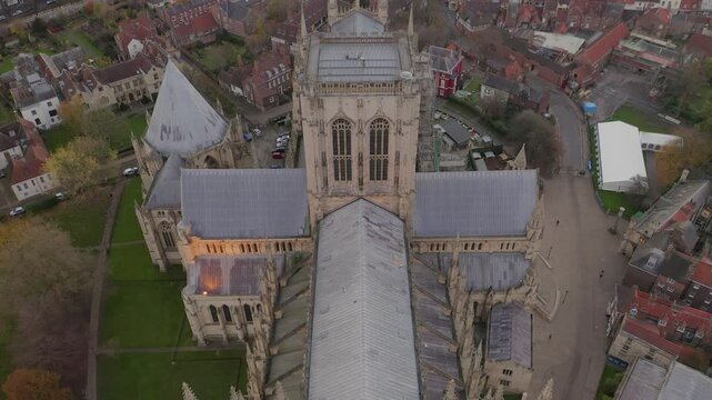 Aerial close-up shot of York Minster Cathedral tilting up to reveal surrounding cityscape in York, England