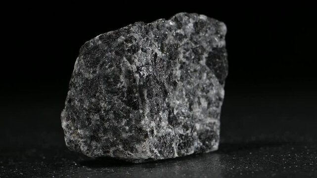Augite (Silicate of calcium, magnesium, iron, titanium and aluminium) mineral sample rotation slowly against a black background. [Norway]