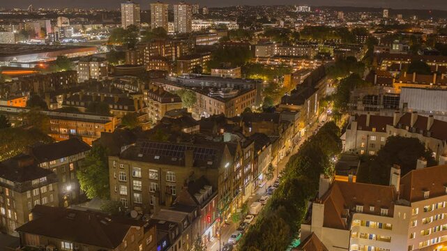 Timelapse of Kings Cross district showing illuminated streets and buildings at night in London, UK