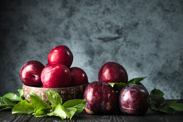 Juicy Summer Plums: Fresh Red and Black Plums on a Rustic Wooden Background