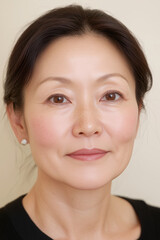 Fototapeta premium Close-up portrait of an elegant 50-year-old woman without makeup, concept of healthy hydrated skin, natural beauty, skincare, sun protection SPF, and beautiful natural aging