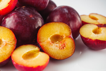 Isolated Summer Plums: Fresh and Juicy Red and Black Plums on a White Background