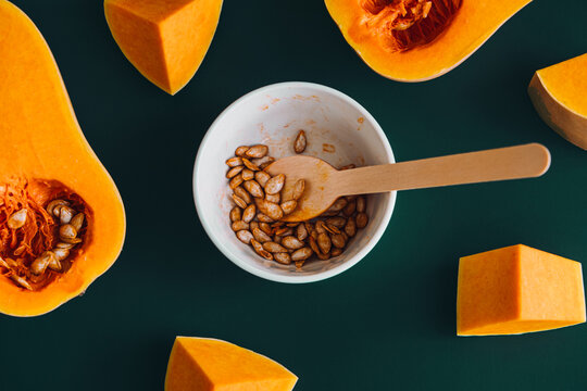 Sustainable Food Practices. Top view of roasted butternut squash seeds and chopped squash, showcasing sustainable cooking and zero-waste food practices