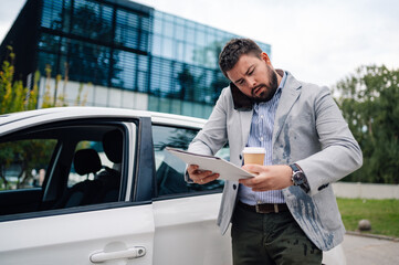 Stressed businessman talking on phone checking documents outside office