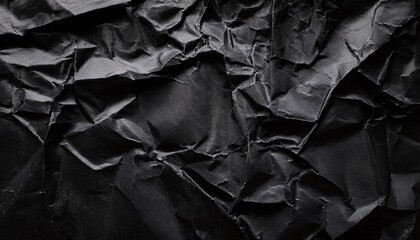 Crumpled black paper with wrinkles and rubbed corners. Old wrapping dusty cardboard. Abstract background texture. For design and titles and headers