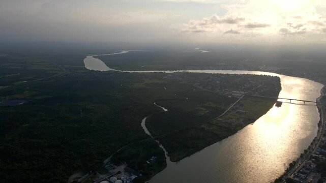 Video aereo de un paisaje en el horizonte sobre el Rio Tuxpan o Rio Pantepec en un atardecer con nuves que reflejan en el agua 