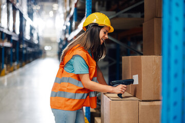 Female warehouse worker scanning barcodes on boxes