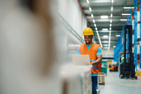 Warehouse worker using laptop checking inventory in distribution center