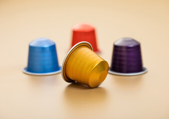 Fresh aroma natural organic coffee aluminium capsules pods on beige background.
