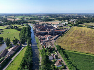 Canal de Bourgogne seen from the sky with fields, meadows, a house and a factory