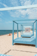Beautiful beach in Yantarny with blue wooden sun beds and blue sky, Baltic Sea. Yantarny, Kaliningrad Oblast , Russia - 23 June 2024