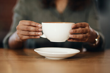 Coffee shop, cup and hands of person with drink, caffeine beverage and cappuccino in cafe. Small business, espresso and closeup of customer with mug in restaurant or diner at breakfast service