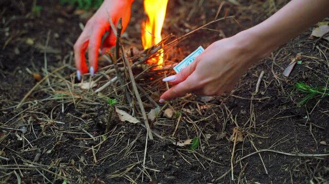 Girl lighting a fire in the forest