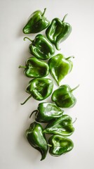 Fresh, vibrant poblano peppers on white surface, perfect for cooking. Top view with copy space for culinary concepts. Burst of flavor for dishes
