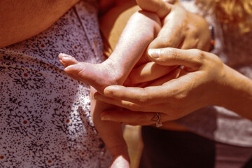 newborn baby being held parents hands showing wedding rings