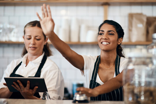Happy woman, waitress and wave with bell at cafe for customer service, call or order on counter. Young, female people or employees with smile for ring up, announcement or notification at coffee shop
