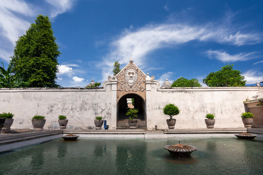 Bathing Area (Umbul Pasiraman) at Taman Sari Water Temple in Yogyakarta, Indonesia with entrance tunnel ahead, and small fountain in middle of pool.