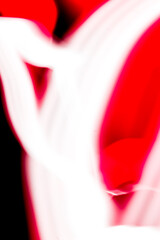 abstract image of dynamic movement of red and white color stripes on a dark background