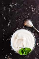 Bowl of tasty fresh sour cream on a dark background with copy space