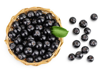Chokeberry with leaf in a wicker basket isolated on white background. Black aronia. Top view. Flat lay