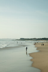 Surfer getting out of the ocean in Carcavelos's beach, Portugal.