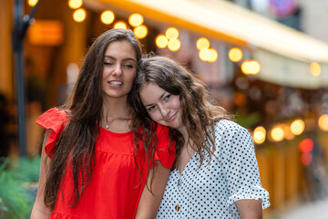 happy meeting of two friends hugging in the street,  defocused lights background