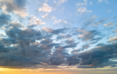 Fototapeta premium A stunning view of fluffy clouds scattered across a bright blue sky at sunset. Perfect for background use or nature-themed projects.