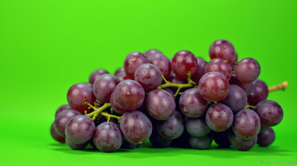 Obraz premium High-Quality Image of Fresh Purple Grapes on Vibrant Green Background - Ideal for Food, Health, and Marketing Projects