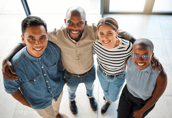 Business people, portrait and team hug in office, startup and collaboration on project in lobby. Employees, high angle and colleagues in meeting with diversity, embrace and together for cooperation