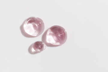 Cosmetic gel or beauty jelly serum texture background. Pink transparent skin care collagen product