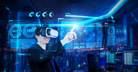 Project manager with VR goggles pointing financial chart and glowing blue light at office. Skilled businessman checking and planning marketing strategy by using data from augmented reality. Ingenuity.