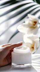   Hand with jar of cream, flowers in background