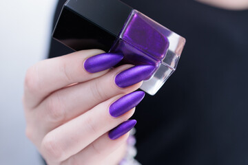Female hand with long nails and a blue and purple color nail polish