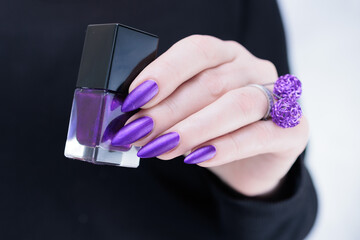Female hand with long nails and a blue and purple color nail polish