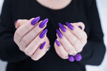 Female hand with long nails and a blue and purple color nail polish