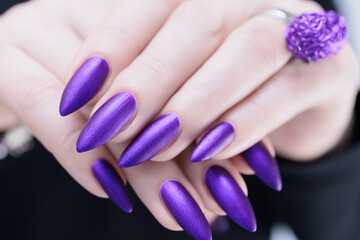 Female hand with long nails and a blue and purple color nail polish