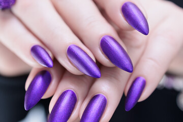Female hand with long nails and a blue and purple color nail polish