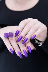Fototapeta premium Female hand with long nails and a blue and purple color nail polish