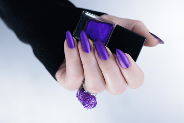 Female hand with long nails and a blue and purple color nail polish