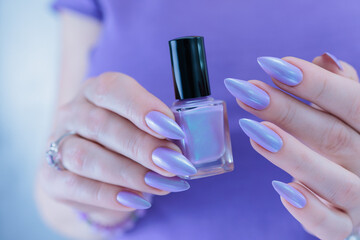 Female hand with long nails and a lilac and blue nail polish