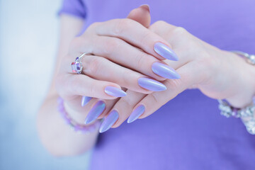 Female hand with long nails and a lilac blue nail polish
