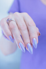 Female hand with long nails and a lilac blue nail polish