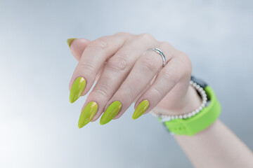 Female hand with long nails and yellow green manicure