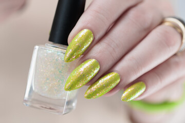 Female hand with long nails and a yellow green nail polish