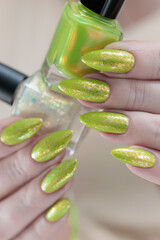 Female hand with long nails and a yellow green nail polish
